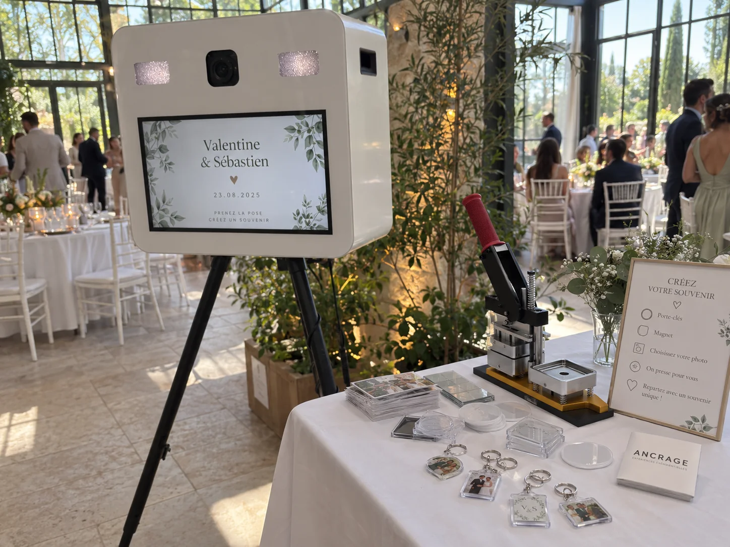 Photobooth blanc et table de souvenirs photo installés sous une verrière